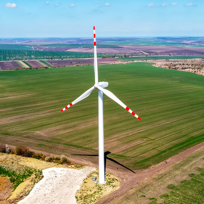 Éolienne surplombant des champs de verdure.